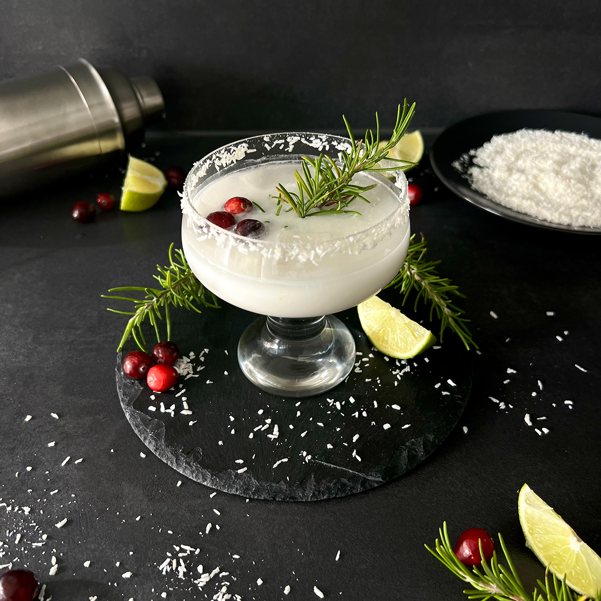 kokosmargarita im Glas, garniert mit Beeren, Zitrone und Kokosraspeln