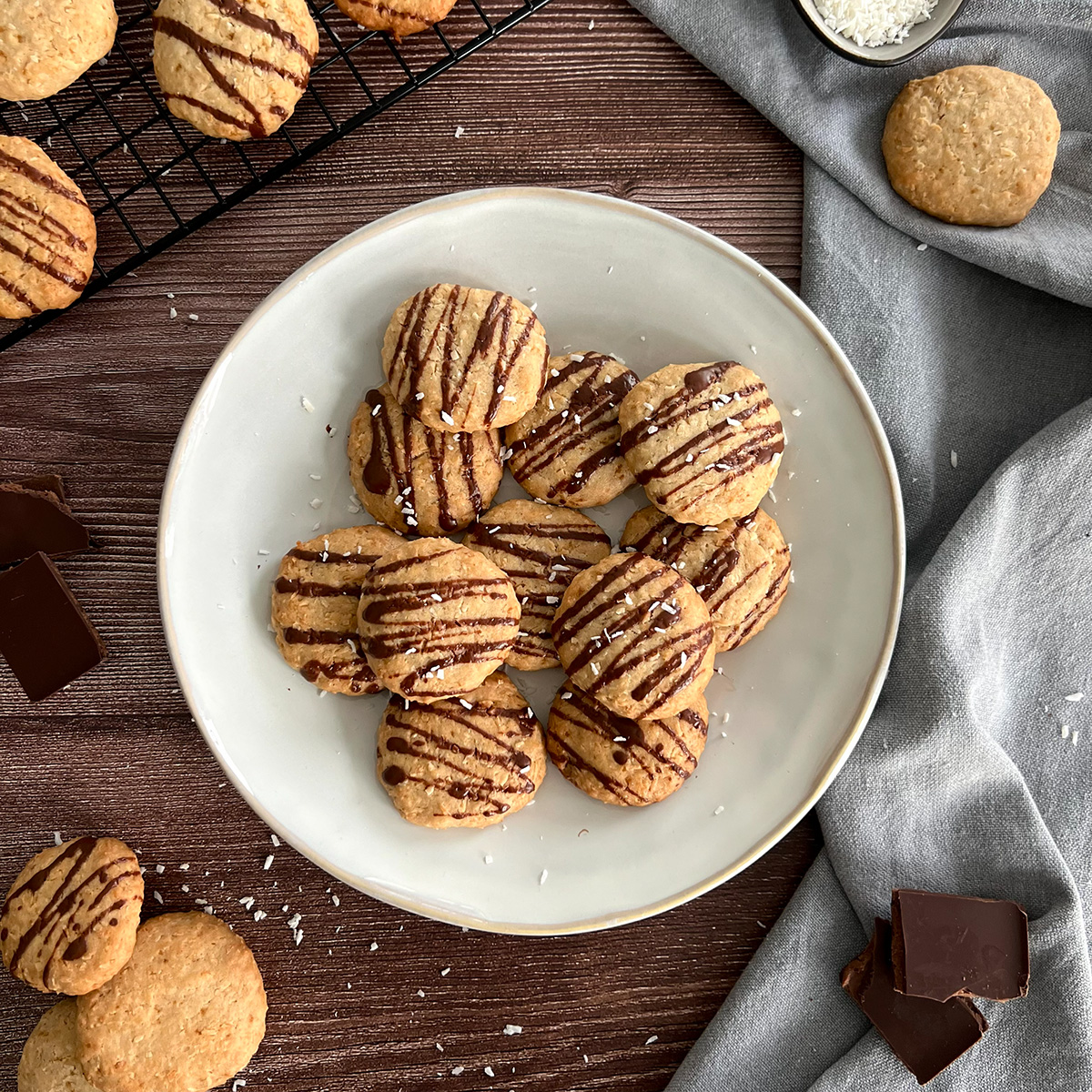 11 Cookies auf einem Teller, daneben weitere und Schokolade