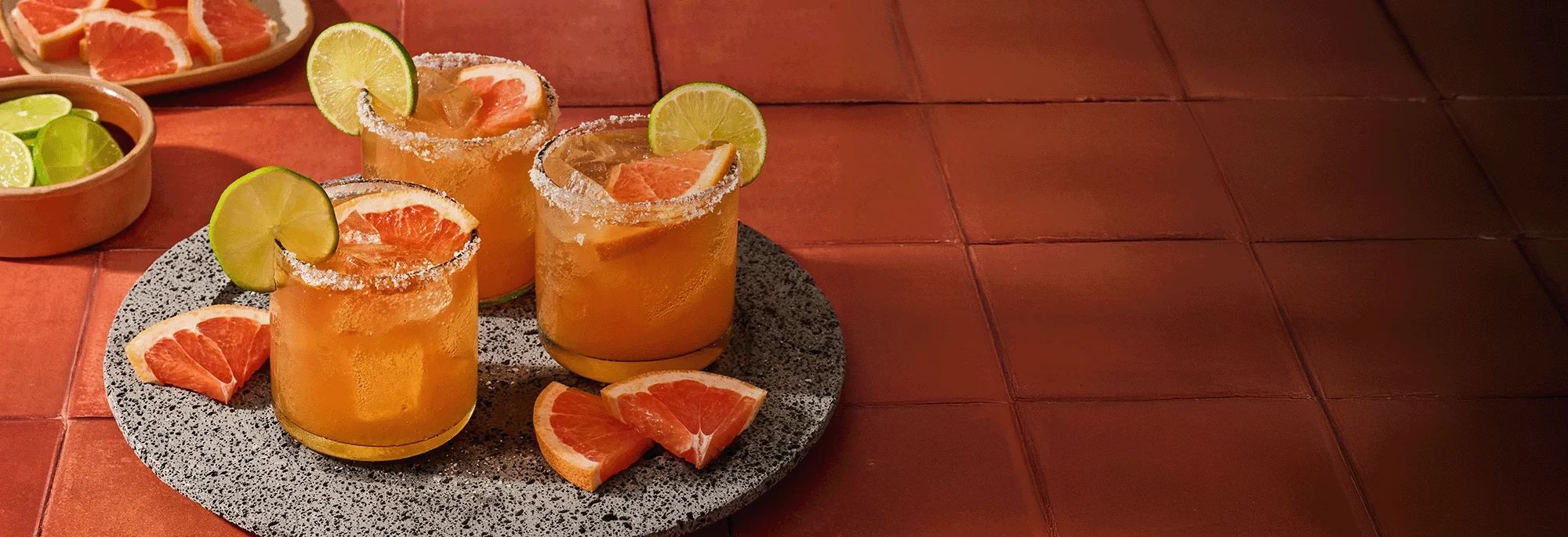 Fertig angerichtete Cocktails mit Limettenscheibe auf Tablett.