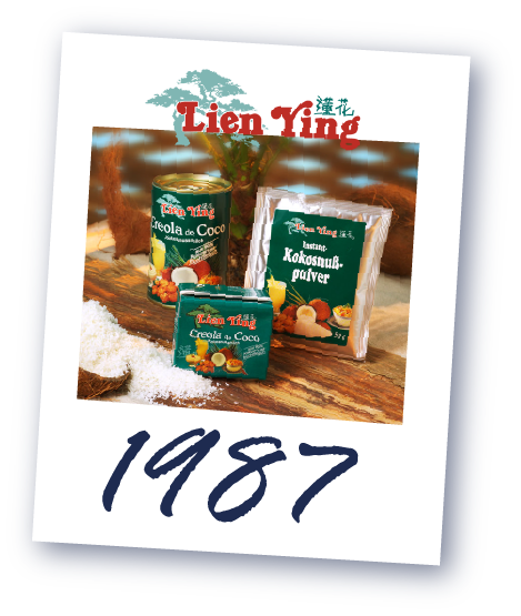 Drei Lien Ying Produkte auf einem Holztisch: Kokosraspel, Kokosnuss-Pulver und Creme de Coco. Darunter die Jahreszahl '1987'.