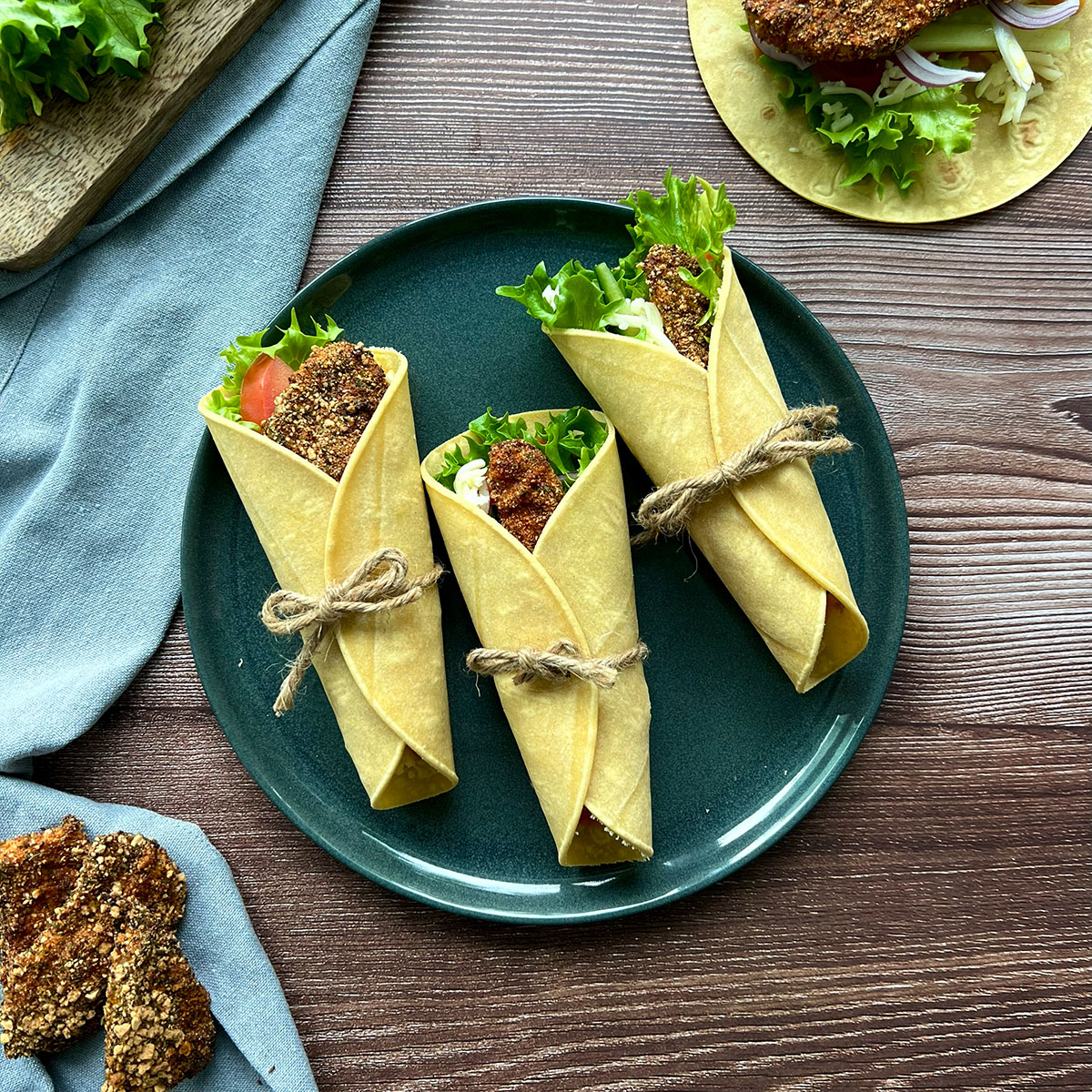 3 wraps auf einem Grünen Teller, daneben die Toppings