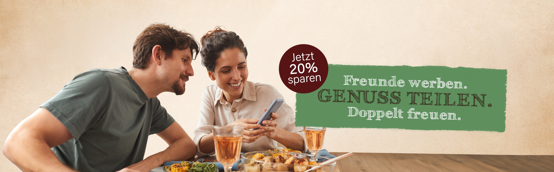 Zwei Personen am Esstisch mit Hinweisschild 20% Rabatt durch Freunde werben.