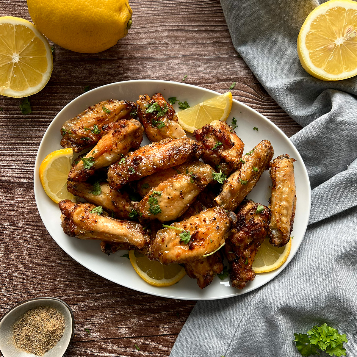 Viele Chickenwings auf einem Teller etoppt mit scheiben einer Zitrone