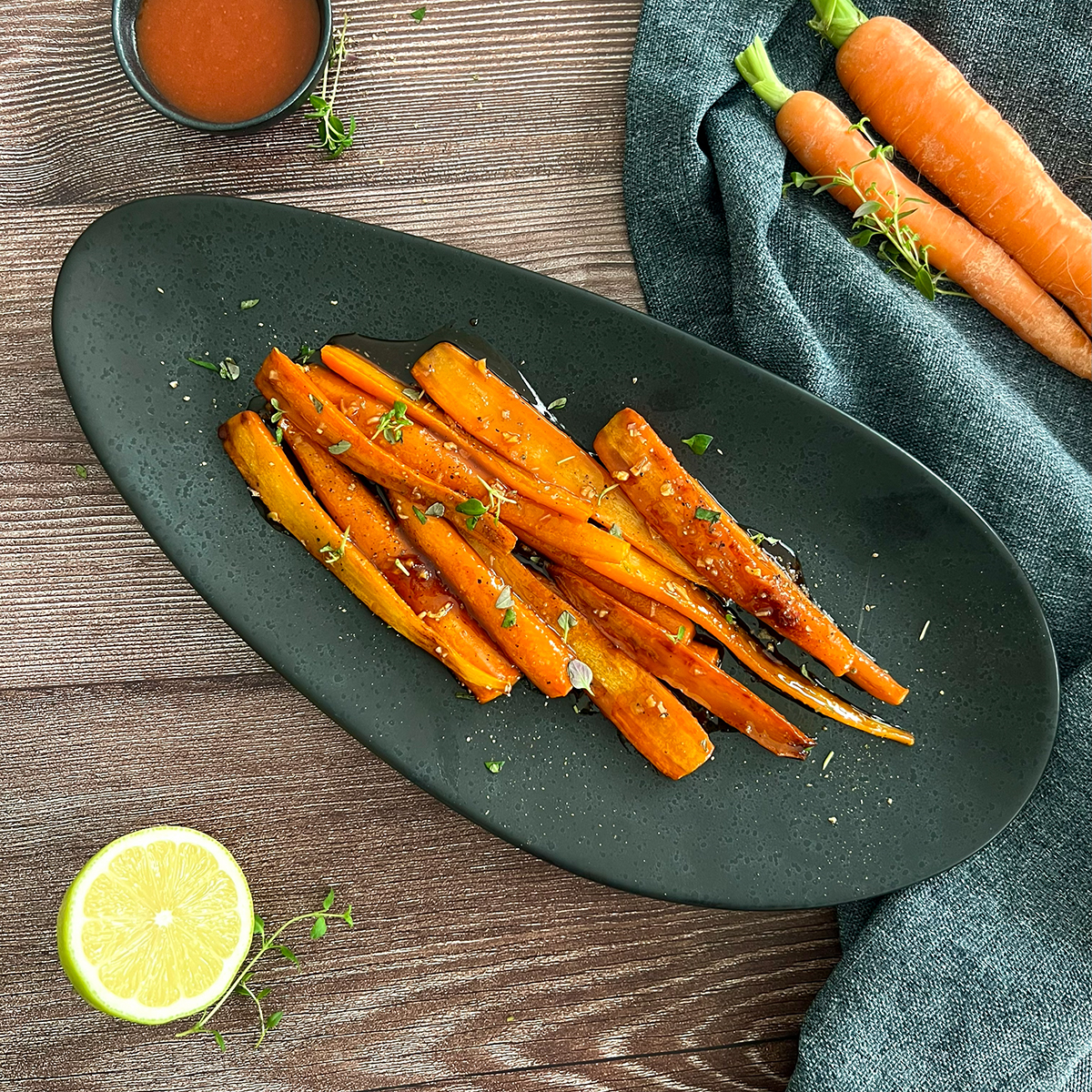 angeröstete Karotten auf einem Teller ganiert mit Kräuern