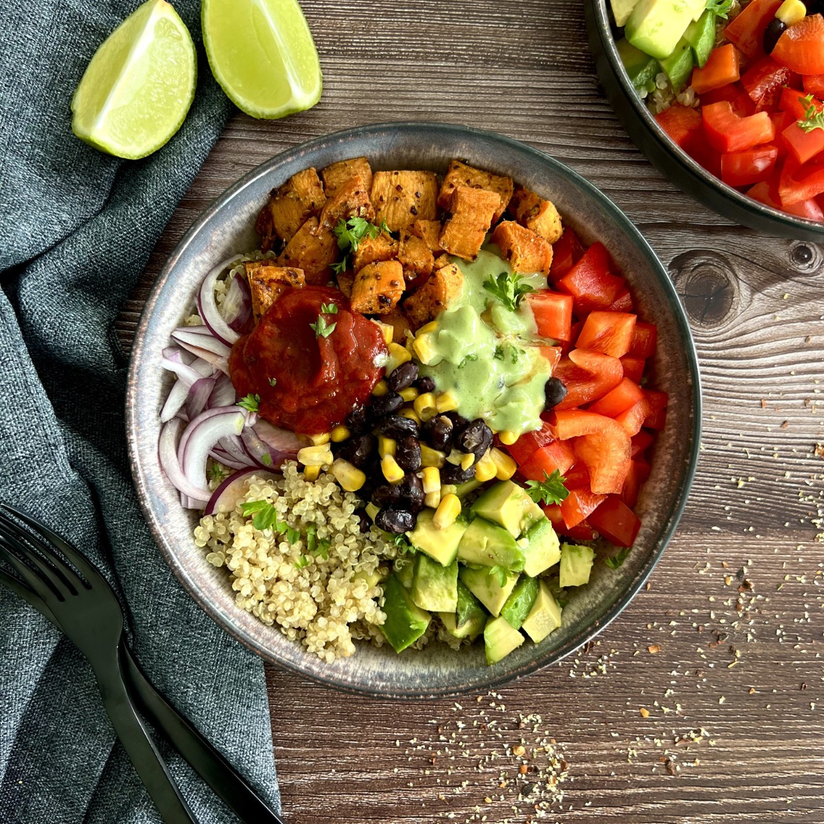 Eine Schale ist gefüllt mit Süßkartoffel, Avocado, Quinoa, Zwiebel, Paprika, Mais, Bohnen, Salsa und Guacamole. Jeder als einzelner Bereich in der Schale.