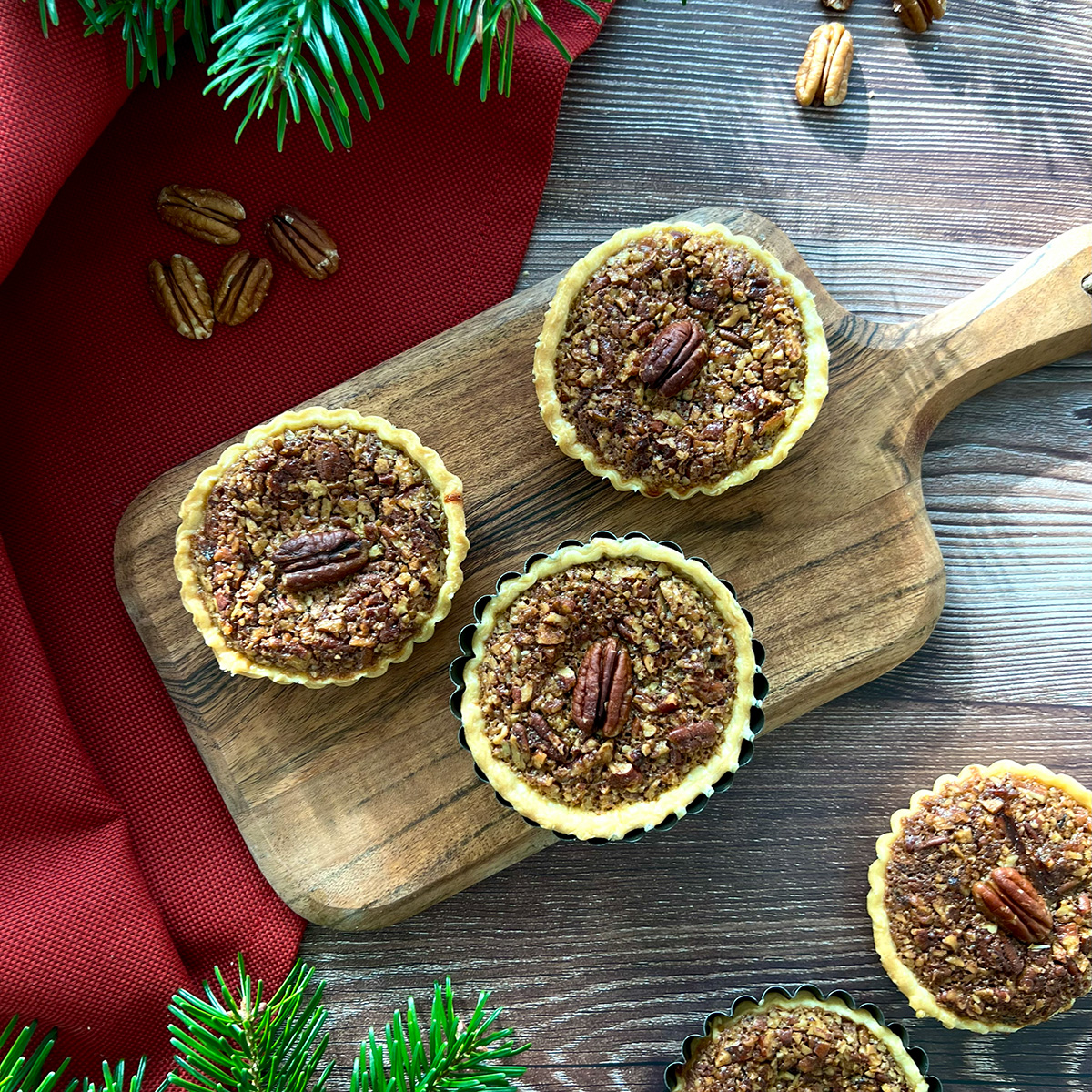 3 pekannussküchlein auf einem Holzbrett 
