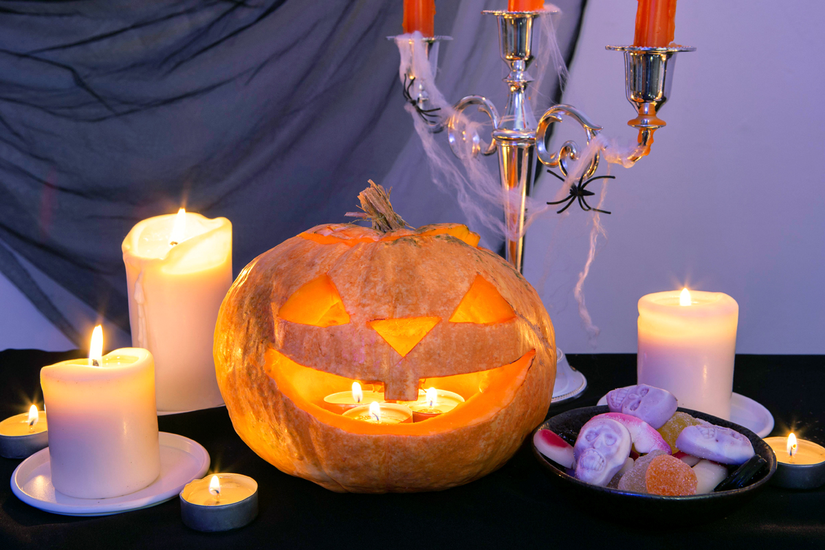 Geschnitzter Halloween Kürbis mit mit Kerzen innen und rundherum