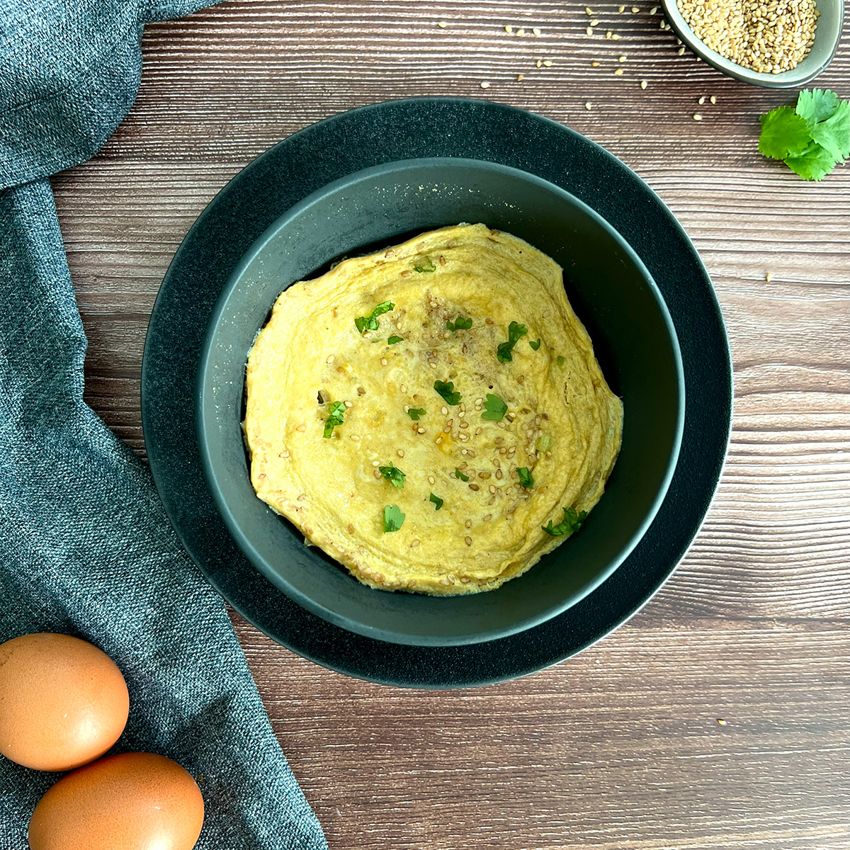 Grüne schüssel mit einem gedämpften ei. Daneben 2 Eier