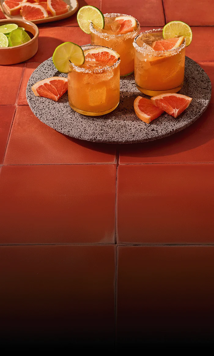 Fertig angerichtete Cocktails mit Limettenscheibe auf Tablett.
