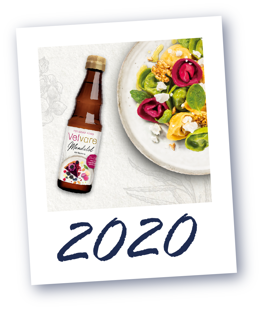 Flasche von Velvare neben einem Teller mit buntem Salat, darunter die Jahreszahl '2020'.