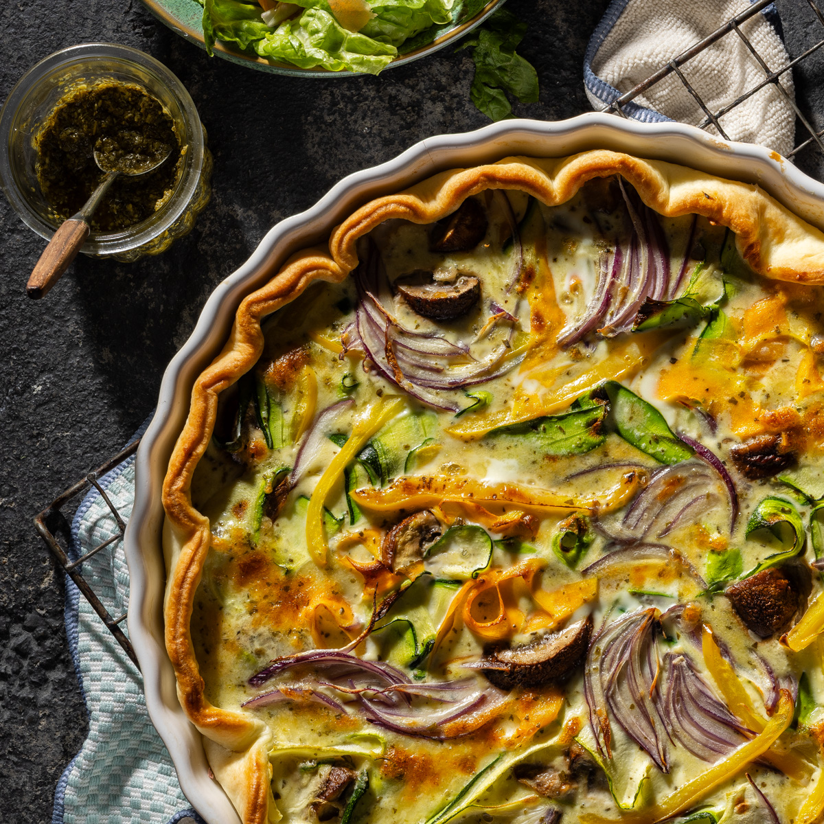 Ein Auflauf in einer Form, daneben Salat und Dressing