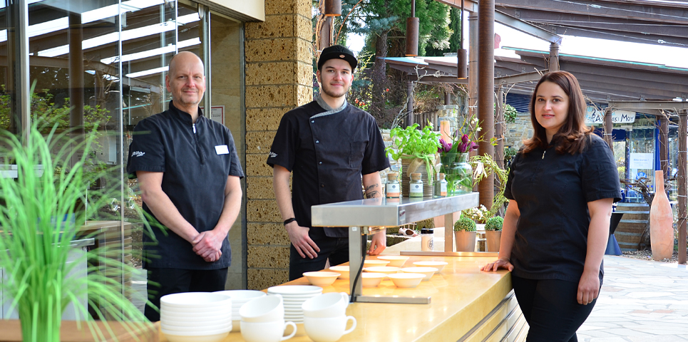 Drei Personen in der offenen Gartenküche bei Rila erleben.