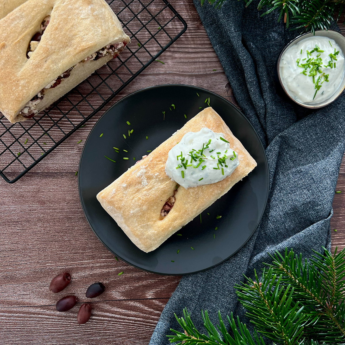 1 Brot auf schwarzem Teller, getoppt it Kraeuterquark