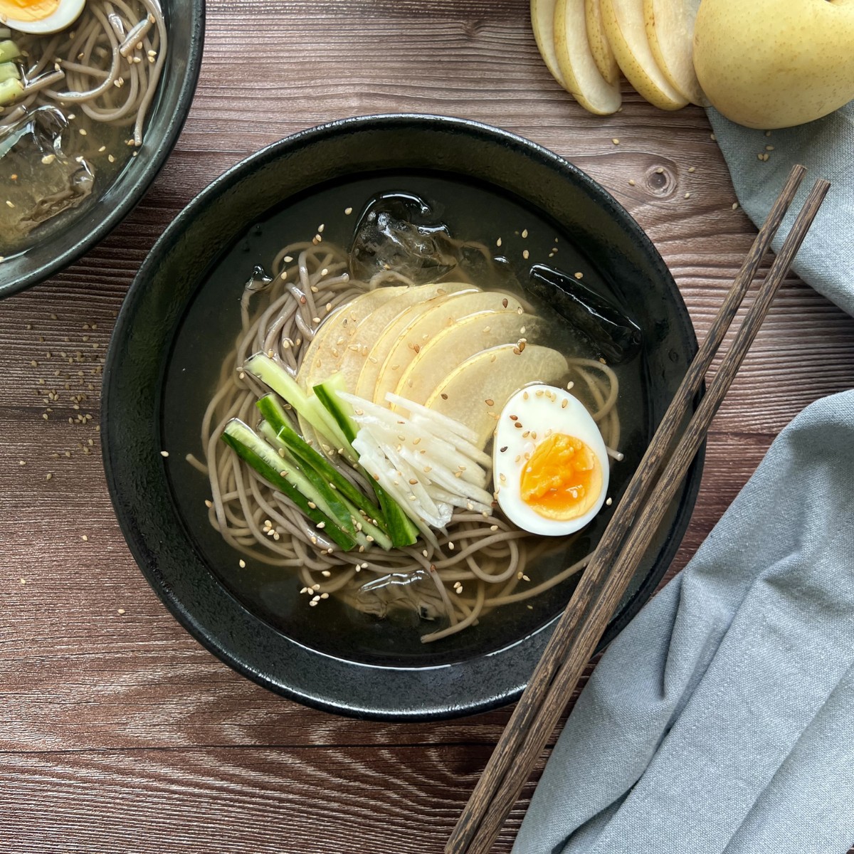 Das Bild zeigt Ramen in einer schwarzen tiefen Schüssel mit Stäbchen.