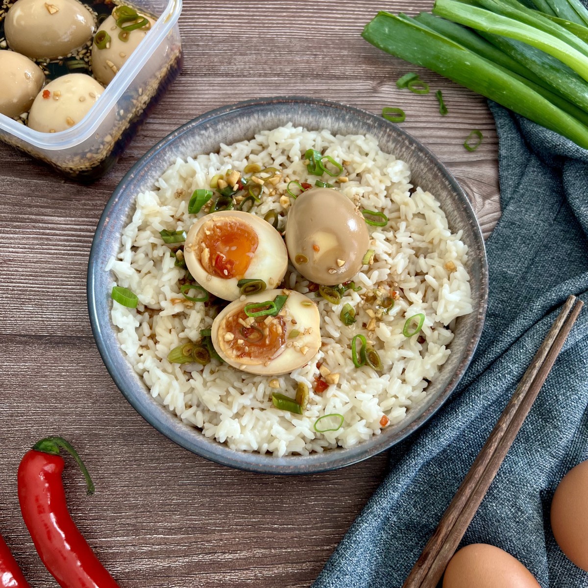 In einer Sojasaucen Marinade über Nacht eingeletge Eier werden in einem tiefem Teller auf Reis serviert.